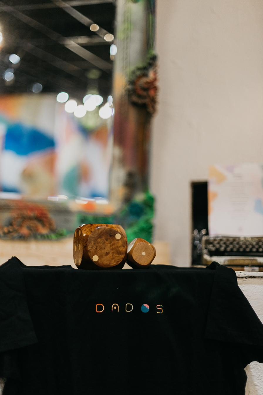 Dados de madera sobre camiseta con el logo DADOS