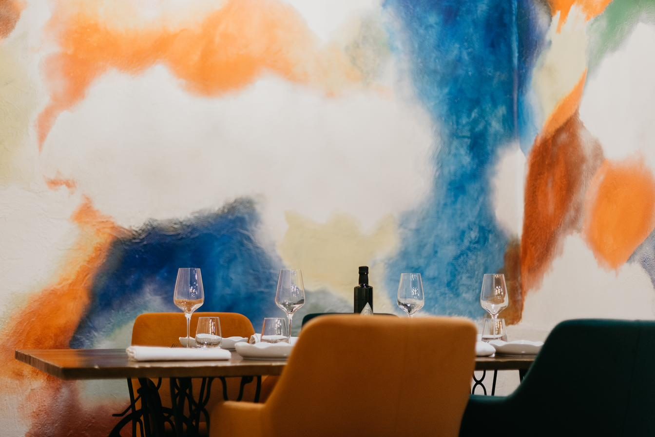 Sala del restaurante con mural de colores al fondo